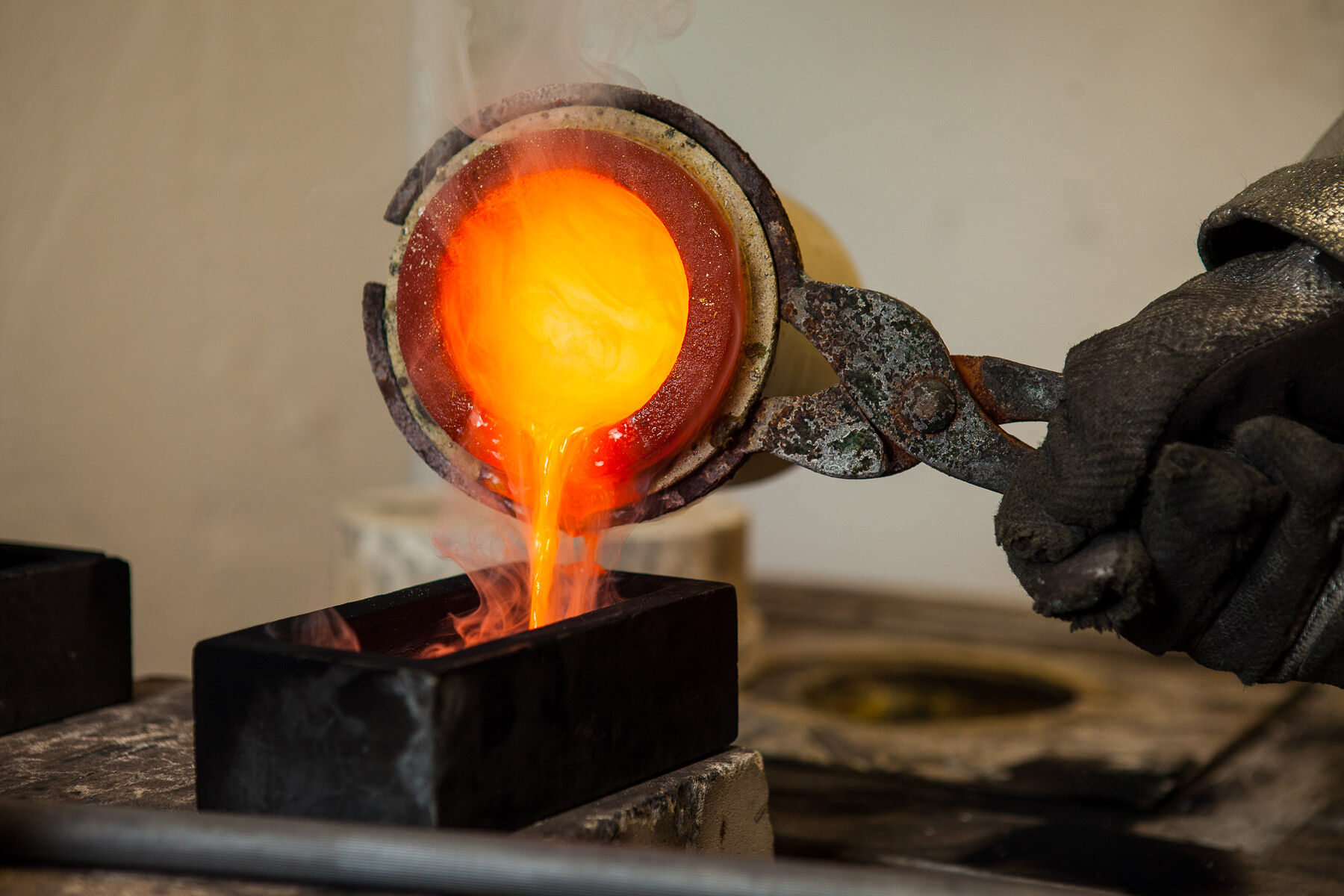 Flüssiges Gold wird aus einem Schmelztiegel in eine Barrenform gegossen