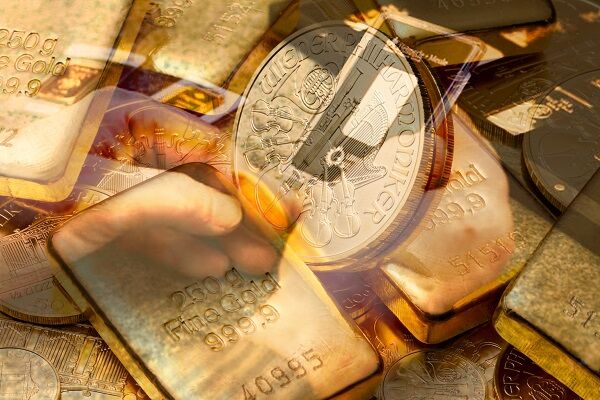 Goldstücke und Goldbarren als Symbolbild für eine Investition in Gold